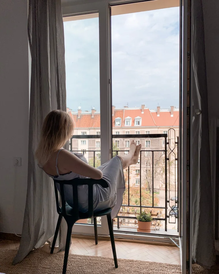 A guest relaxing on an apartment balcony overlooking the town